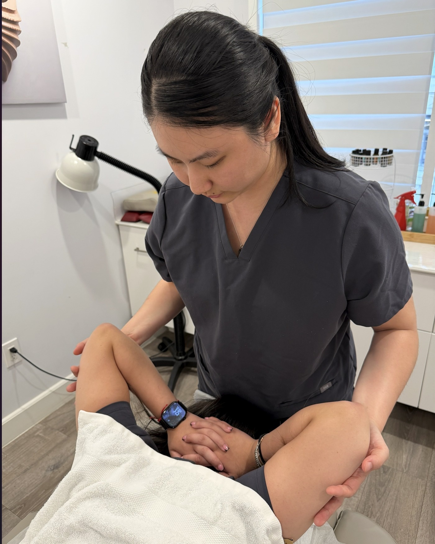 Lily Wong performing therapeutic massage treatment on a client
